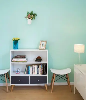 a white book shelf against a blue wall at Cozy Flat With Unbeatable Views to Sagrada Familia in Barcelona