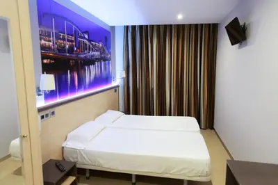 a hotel room with a bed and a painting on the wall at Hostal Las Flores Ramblas in Barcelona