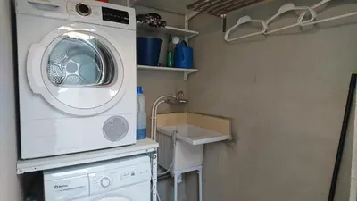 a bathroom with a washing machine and a sink at Cal Ton M in Castelltersol