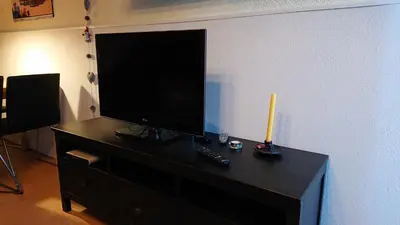 a flat screen tv sitting on top of a black cabinet at Cal Ton M in Castelltersol