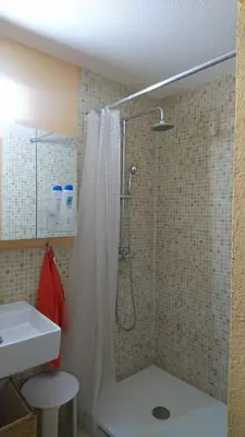 a shower with a shower curtain in a bathroom at Cal Ton M in Castelltersol
