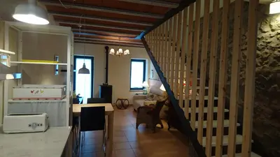 a kitchen and dining room with a table and a staircase at Cal Ton M in Castelltersol