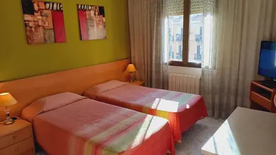 a hotel room with two beds and a television at Plaza Universitat in Barcelona