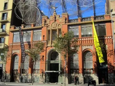 a large brick building with a yellow sign on it at Plaza Universitat in Barcelona