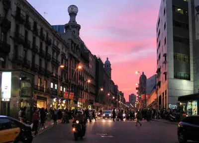 a busy city street at night with people and cars at Plaza Universitat in Barcelona