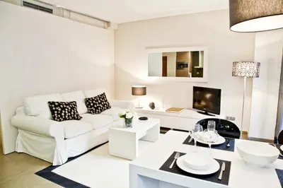 a living room with a white couch and a table at Up Suites BCN in Barcelona