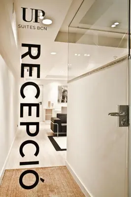 a lobby with a couch and a glass door at Up Suites BCN in Barcelona