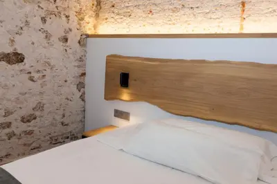 a bedroom with a bed with a wooden headboard at Hostal Paris in Barcelona