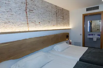 a bedroom with a bed and a brick wall at Hostal Paris in Barcelona