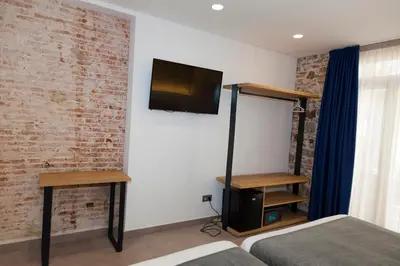 a bedroom with a bed and a tv on a wall at Hostal Paris in Barcelona