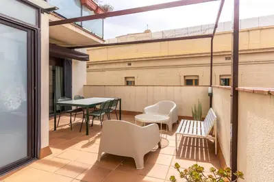 a patio with a table and chairs on a balcony at Céntrico apartamento con terraza in Barcelona