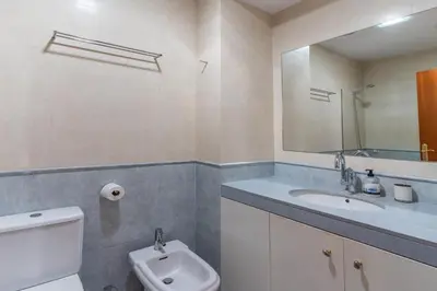 a bathroom with a sink and a toilet and a mirror at Céntrico apartamento con terraza in Barcelona
