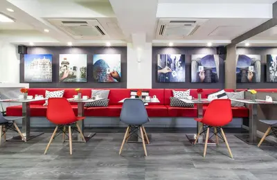 a restaurant with a red couch and red chairs at Leonardo Boutique Hotel Barcelona Sagrada Familia in Barcelona