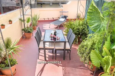 a table and chairs on a balcony with plants at Private Roof Top Sant Antoni in Barcelona