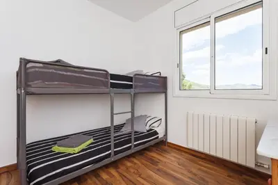 a bunk bed in a room with a window at HHBCN Can Surià in Olivella