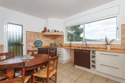 a kitchen with a table and a dining room at HHBCN Can Surià in Olivella