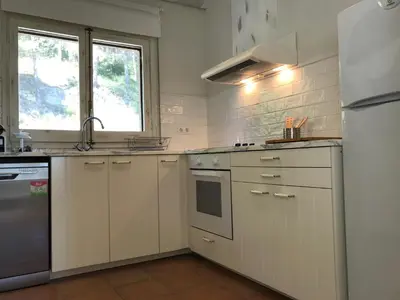 a kitchen with white cabinets and a sink and a refrigerator at Montserrat La Calsina in Monistrol