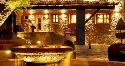 a large fountain in front of a building at night at Fonda La Masia Del Sola in Monistrol de Calders
