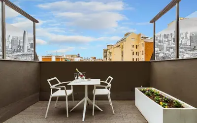 a table and chairs on a balcony with a view of a city at Grums Hotel & Spa in Barcelona