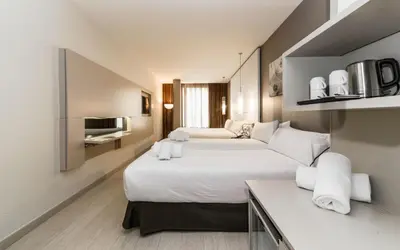 a hotel room with two beds and a tv at Grums Hotel & Spa in Barcelona