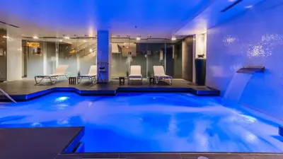 a pool with chairs and a table in a building at Grums Hotel & Spa in Barcelona