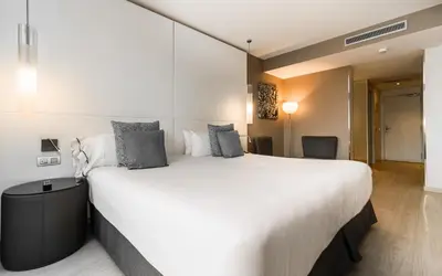 a large white bed in a hotel room at Grums Hotel & Spa in Barcelona