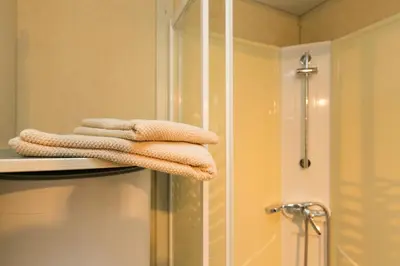 a pile of towels sitting on a shelf in a bathroom at Camping Bungalows El Far in Calella