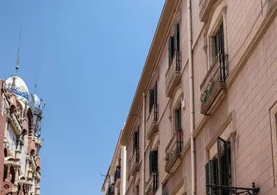 a building with balconies and a clock on the side of it at Hostal del Palau in Barcelona