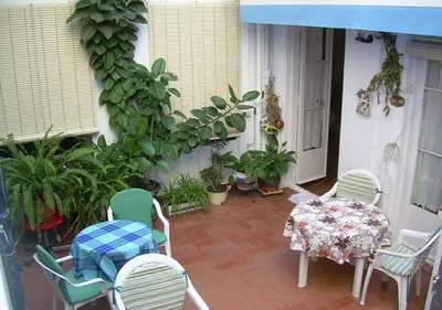 a patio with a table and chairs and plants at Hostal del Palau in Barcelona