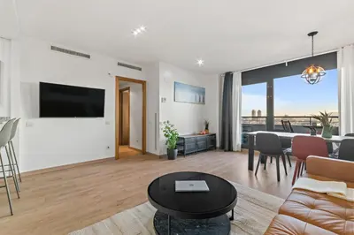 a living room with a large tv and a table at Tendency Apartments 3 in Barcelona