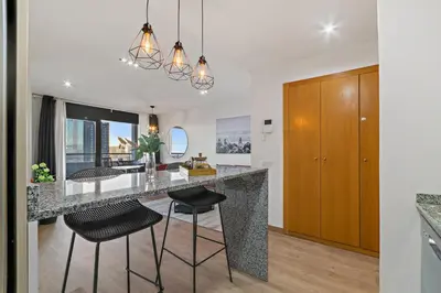 a kitchen with a large island with stools and a counter top at Tendency Apartments 3 in Barcelona