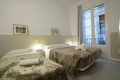 a hotel room with two beds and a window at Hostal Hera in Barcelona