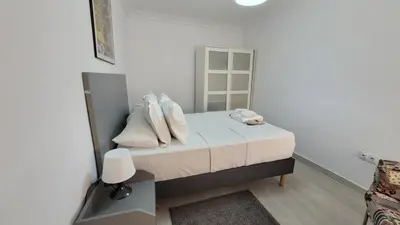 a bedroom with a bed with white sheets and pillows at APARTAMENTS B O D CoLLBLANC in Hospitalet de Llobregat