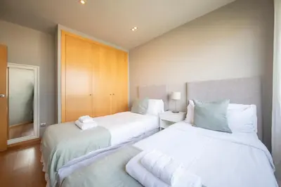a bedroom with two beds with white sheets at You Stylish Beach Apartments in Barcelona