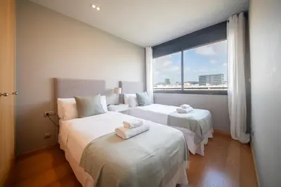a bedroom with two beds and a large window at You Stylish Beach Apartments in Barcelona