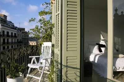 a balcony with a bed and a chair on a balcony at Balcones y Vistas en el Centro de la Ciudad in Barcelona