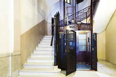 a hallway with stairs and a wooden door at Balcones y Vistas en el Centro de la Ciudad in Barcelona