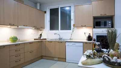 a kitchen with wooden cabinets and a white dishwasher at Balcones y Vistas en el Centro de la Ciudad in Barcelona