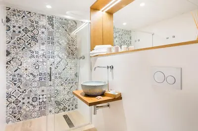 a bathroom with a bowl on a shelf next to a shower at Apartamentos Porta Coeli in Castelldefels