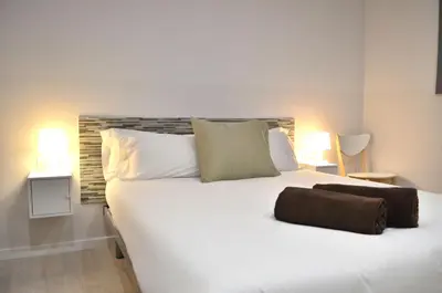 a bedroom with a white bed with two towels on it at Poble Sec Apartments in Barcelona