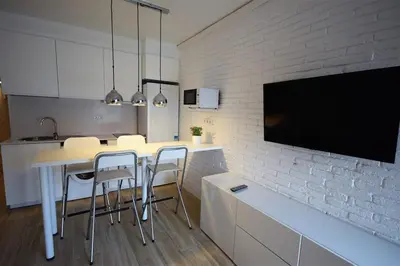 a kitchen with a table and chairs and a tv at Apartamento Playa Mar in Castelldefels