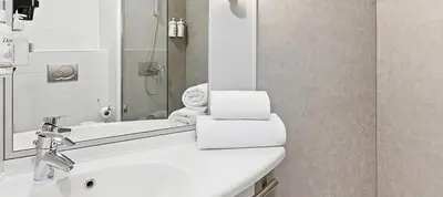 a white bathroom with a sink and a shower at B&B HOTEL Barcelona Mataro in Mataró