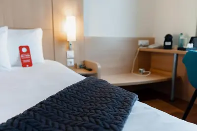 a restaurant with tables and chairs and windows at Ibis Barcelona Mollet in Mollet del Vallès