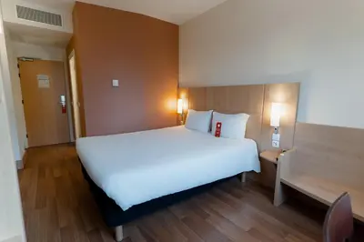 a group of white tables and chairs with an umbrella at Ibis Barcelona Mollet in Mollet del Vallès