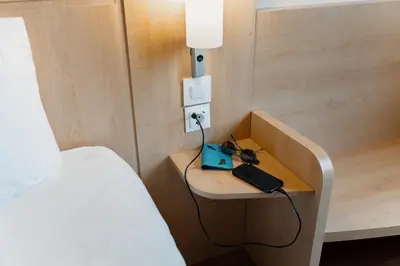 a hotel room with a bed and a desk with a laptop at Ibis Barcelona Mollet in Mollet del Vallès