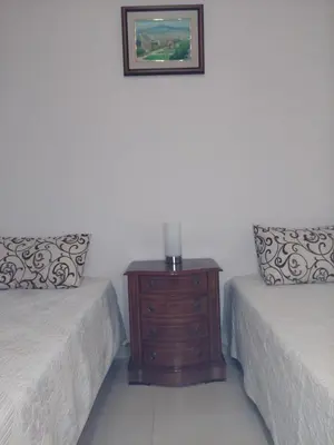 a bedroom with two beds and a table with a candle on it at Apartamento Gran Via de les Corts Catalanes in Barcelona
