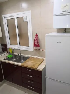 a kitchen with a sink and a white refrigerator at Apartamento Gran Via de les Corts Catalanes in Barcelona