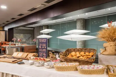 a table with baskets of bread and other food at Hotel Madanis Liceo in Hospitalet de Llobregat
