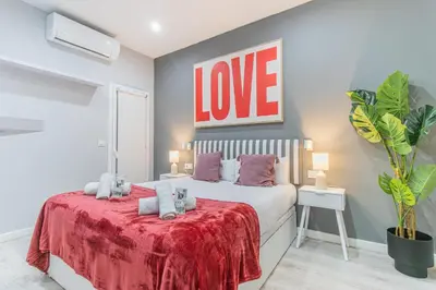 a bedroom with a bed with a red blanket at Fira Rooms Barcelona Hospitalet in Hospitalet de Llobregat