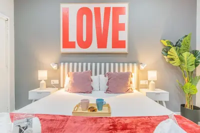 a bedroom with a bed with a love sign above it at Fira Rooms Barcelona Hospitalet in Hospitalet de Llobregat